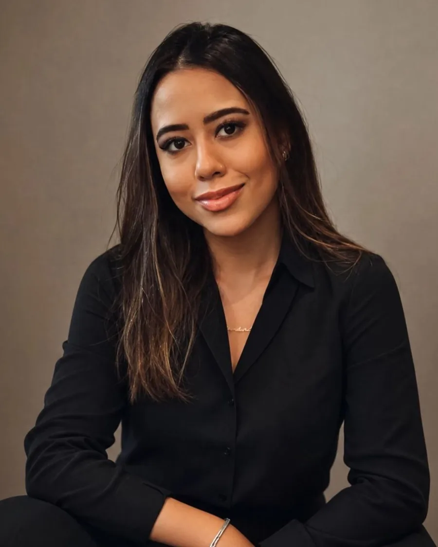 Retrato profissional de Amanda Terra, de camisa preta, com fundo escuro